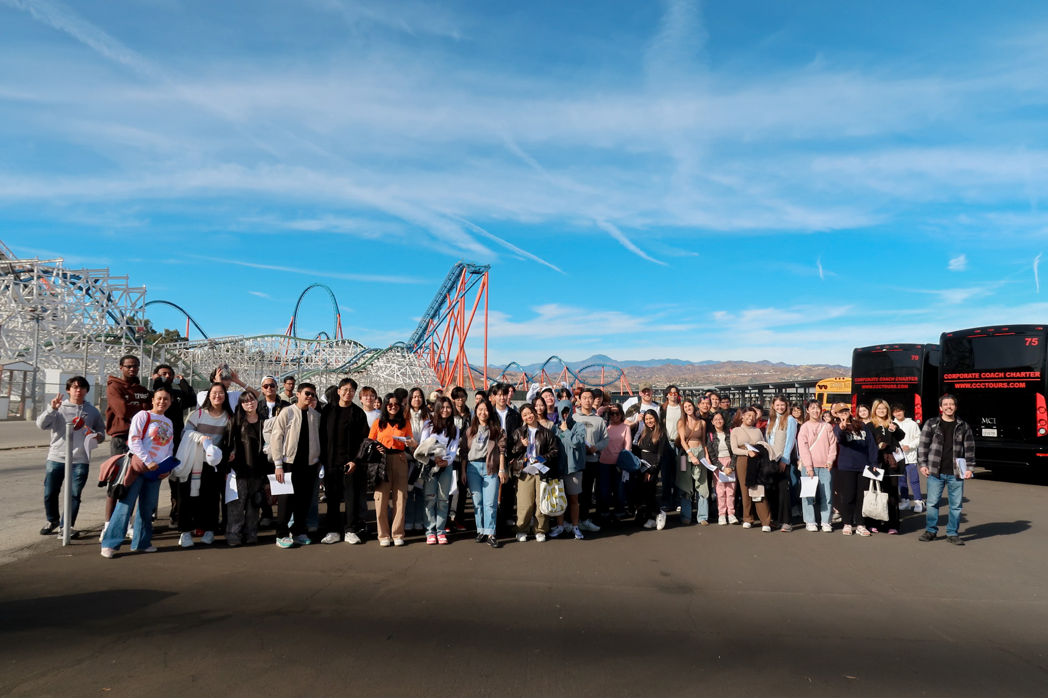 students in front of rollercoaster
